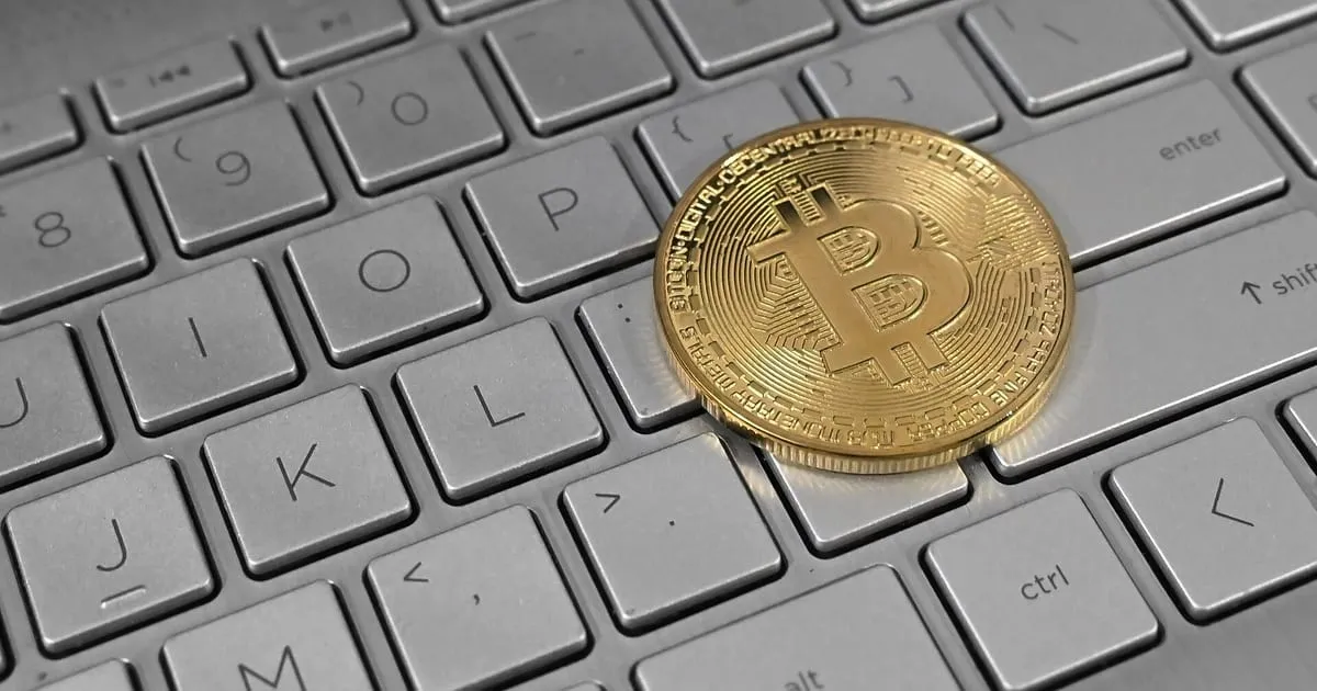 Pièce physique à l’effigie du bitcoin posée sur un clavier d’ordinateur