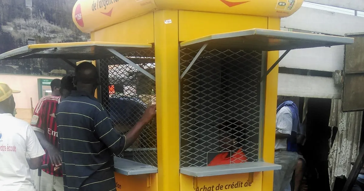 Gérant d’un kiosque Mobile Money servant un client au Cameroun