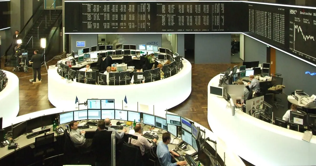 Vue d’une salle de marché avec des postes de trading et des écrans de cotation