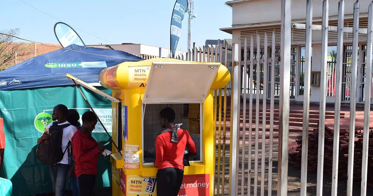 Kiosque de paiement mobile money avec un client et son téléphone